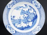 une assiette bleue et blanche sur laquelle figure l'image d'un homme à cheval