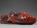 an image of a red fish figurine sitting on top of a table