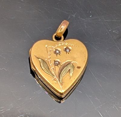 un cadenas doré en forme de cœur orné d'un motif floral