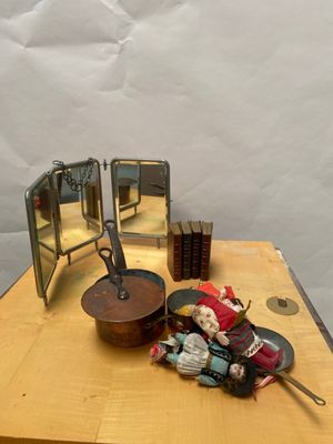 une petite poupée posée sur une table, à côté d'un miroir