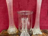 trois vases posés sur une table en bois, sur fond rouge