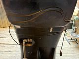 a large black water tank sitting on top of a wooden floor