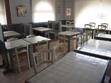 de nombreuses tables et chaises dans un restaurant doté de nombreuses fenêtres