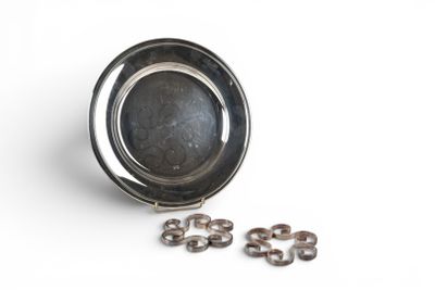 a small metal bowl with rings in it on a white surface