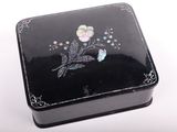 une petite boîte noire ornée d'un motif floral