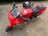a red motorcycle parked on the side of the road