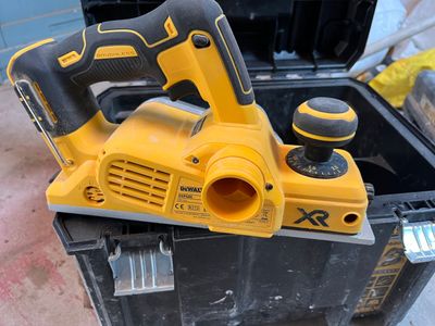 a yellow corded planer sitting on top of a black box