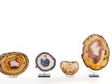 Plusieurs types d'agates sont exposés sur des présentoirs posés sur une surface blanche.