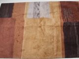 un tapis marron, marron et noir posé sur une table blanche