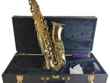 an image of a saxophone sitting in a case with other items in it