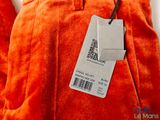 an orange pants with a price tag hanging on a hanger