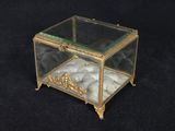 une petite boîte en verre contenant une bille, posée sur une surface noire