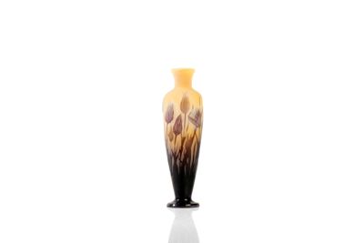 a black and yellow vase sitting on a white surface