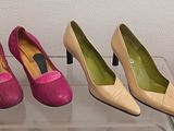 trois paires de chaussures à talons hauts roses et jaunes posées sur une étagère transparente