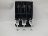 trois verres à vin vides dans une boîte noire sur fond blanc