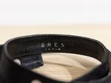 black leather belt with a metal buckle on a wooden surface