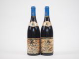 deux bouteilles de vin rouge posées l'une à côté de l'autre sur une surface blanche