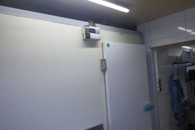 un réfrigérateur blanc dans une petite pièce où la lumière est allumée