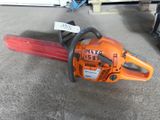 an orange chainsaw sitting on top of a floor next to a pile of other items