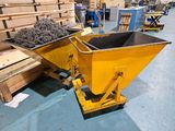 a large yellow dumpster sitting in the middle of a warehouse floor