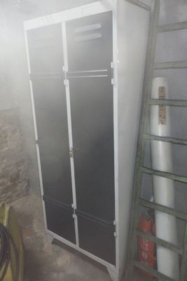 une armoire haute dans une pièce, avec une échelle à côté