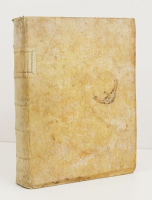 un vieux livre posé sur une table blanche à côté d'un mur blanc