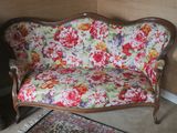 a floral couch in a room with a rug on the floor