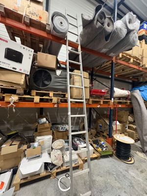 un homme debout dans une pièce où les étagères sont remplies de cartons