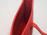 a red purse that is sitting on a white table