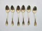 six silver spoons are lined up in a row on a white surface