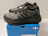 Chaussures de course adidas pour homme, dans une boîte posée sur une surface blanche
