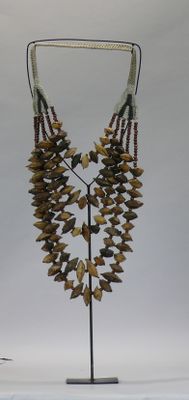 a necklace made of yellow and brown stones on a stand
