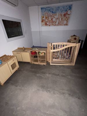 une chambre avec un lit, un bureau et un lit bébé