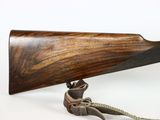 a close up of a rifle with a wooden barrel on a white background