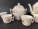 four cups and a teapot sitting on a table