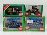 three boxed boxes of toy farm equipment including a tractor and a trailer