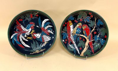 deux assiettes avec des oiseaux peints dessus, posées sur une table