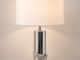 une table blanche sur laquelle est posée une lampe, près d'un mur