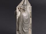 an old silver statue of a woman with a hat on her head