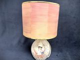 a lamp that has a pink shade on top of it