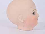 a small head of a doll on a white surface