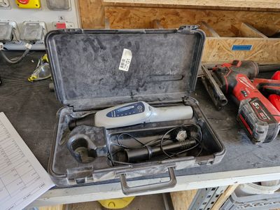 une boîte à outils contenant des outils, posée sur un établi