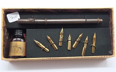 une boîte contenant un stylo, un encrier et d'autres objets