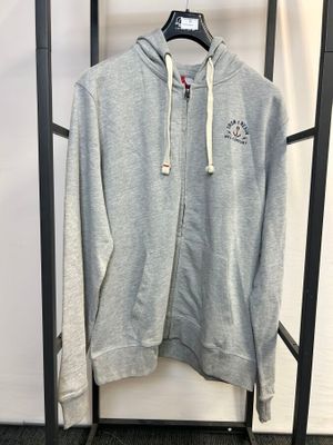 Le sweat à capuche gris est suspendu à un portant dans une pièce