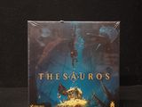 the sauros board game in a plastic bag on a black background
