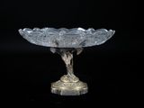 un bol en verre posé sur un socle, sur fond noir