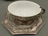 a white bowl sitting on a silver plate on a table