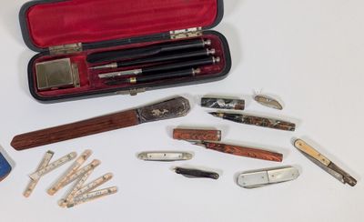 de nombreux types de stylos et de couteaux dans un étui