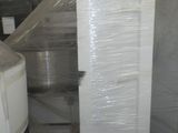 une grande pile de cartons blancs posée sur une palette dans un entrepôt