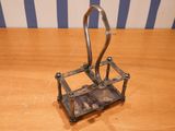 a metal holder with a hook on it on a wooden table